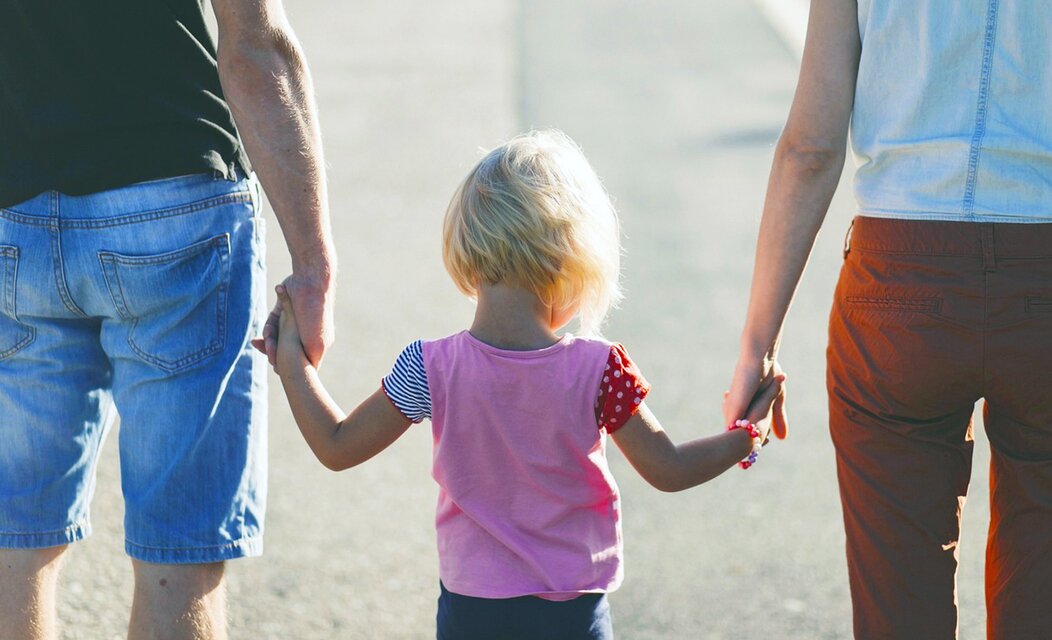 Photo de deux parents promenant leur enfant