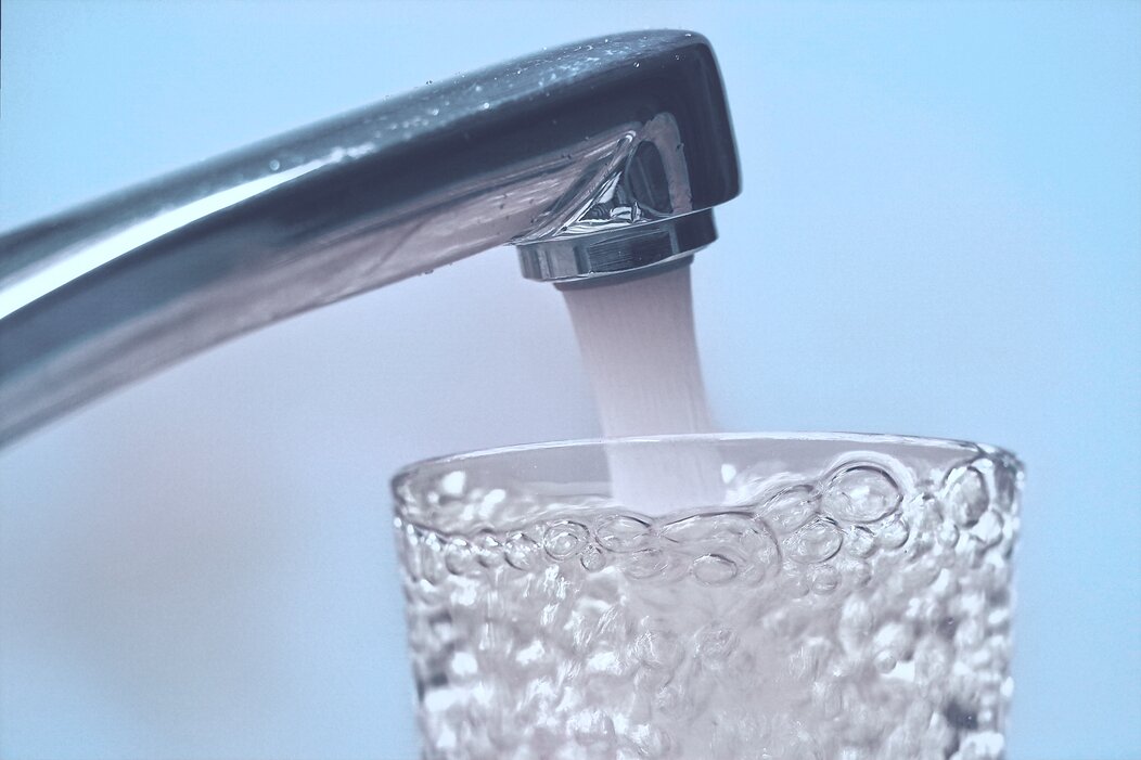 Photo d'un robinet avec un verre d'eau